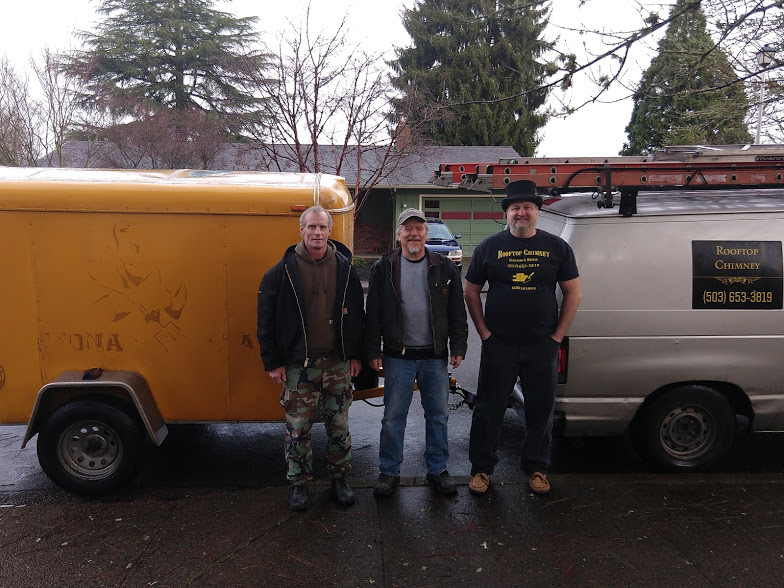 the-crew Three men standing between service vehicles outdoors.