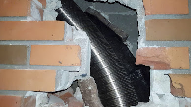 Flexible duct going through a brick wall.